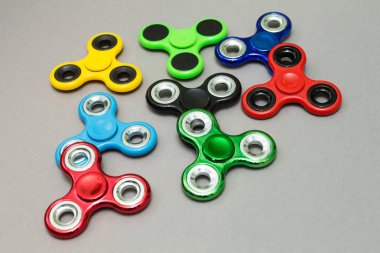 Çok renkli gri arka plan üzerinde parmak spinner stres kıpır.