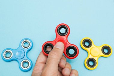 Erkek el, popüler hareketli döner oyuncağı tutuyor.