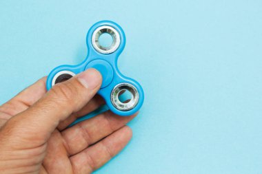 Popüler tutan erkek el kıpır spinner oyuncak mavi zemin üzerine