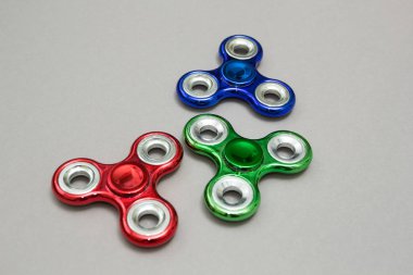 Gri arka plan üzerinde grup kıpırdamak spinner stres giderici oyuncak.