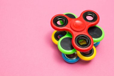Spinner stres giderici oyuncak pembe bir arka plan üzerinde kıpır.