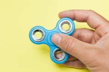 El tutma mavi popüler topluca spinner oyuncak Sarı zemin üzerine