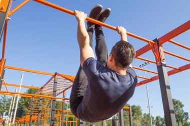 Adam parkta mide egzersizleri yapıyor. Arkadan görüntülemek.