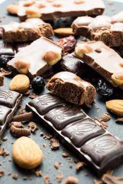 Siyah bir arka plan üzerinde dikey olarak bir slayt çikolata ve kurutulmuş meyveler.