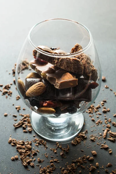 A glass of chocolate on a black background, crumbs of chocolate.