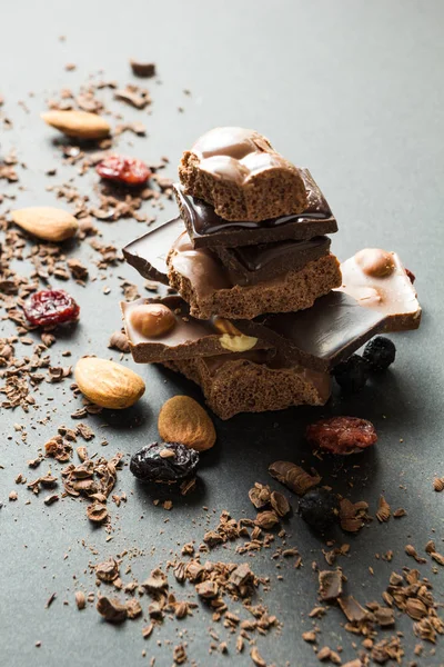 Çikolata ve kurutulmuş meyveler siyah bir zemin üzerine dikey olarak piramit.