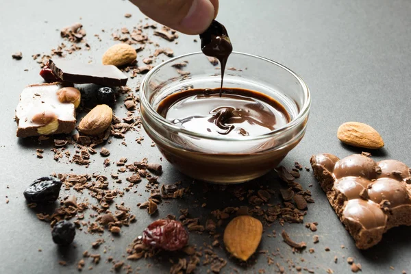 Vloeibare Chocolade Een Achtergrond Van Kruimels Gedroogde Bessen Snoep — Stockfoto