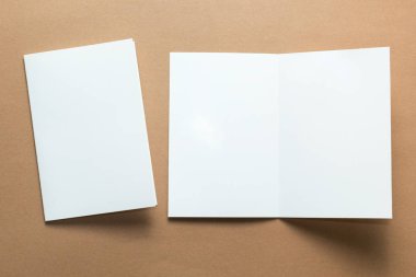 Kartvizit, broşür dergi izole kahverengi zemin üzerinde beyaz kağıt. mockup