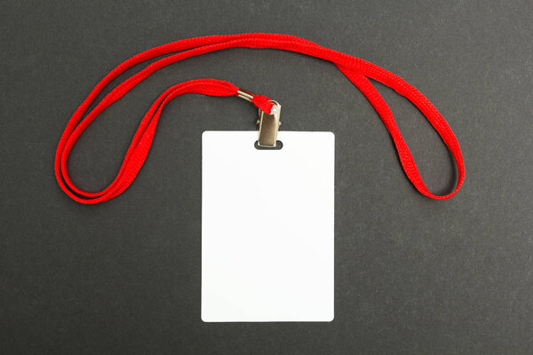 Blank badge mockup isolated on black. Plain empty name tag mock up with red string.