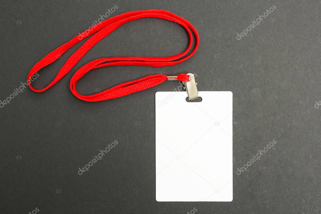 Blank badge mockup isolated on black. Plain empty name tag mock up with red string.