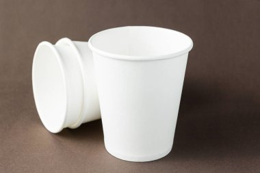 Mockup kahverengi arka plan, metin veya l için alan üzerinde beyaz kağıt bardaklar