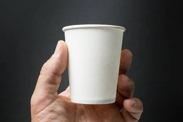 Mockup de mão masculina segurando uma xícara de café, chá ou suco de papel iso — Fotografia de Stock
