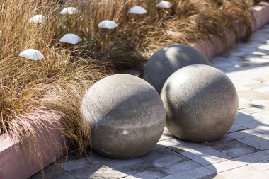 Sarı çim zemin üzerinde üç büyük beton küreler, 