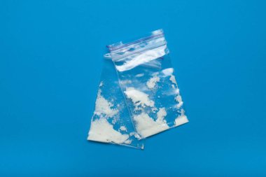 Mavi bir arka plan üzerinde plastik torbalarda kokain yakın çekim.