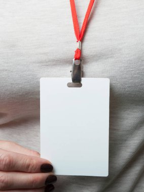 Blank badge mockup in a woman's hand on the background of grey c clipart