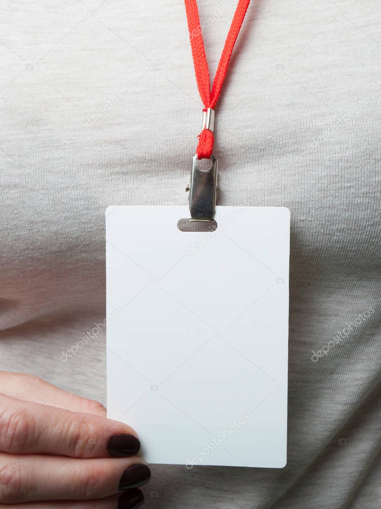 Blank badge mockup in a woman's hand on the background of grey c