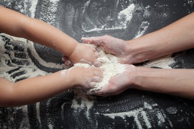 Eller bir anne bir kızı pişirmek için küçük bir kız öğretmek. T