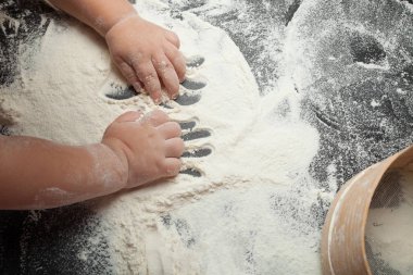 Küçük bir kız hamur un ev yapımı kek yemek için gelen kneads