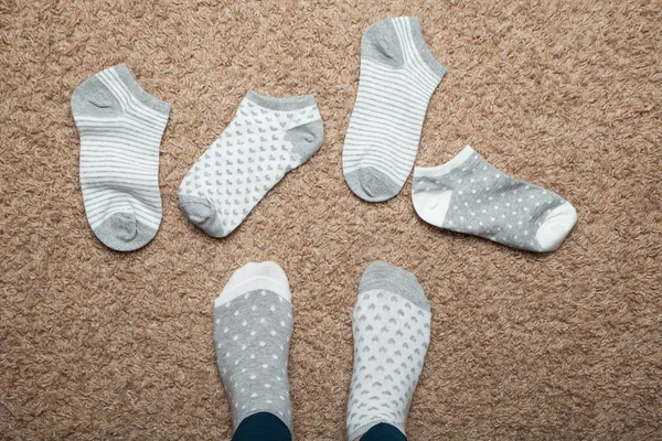 Socks with different patterns scattered on the floor in the hous