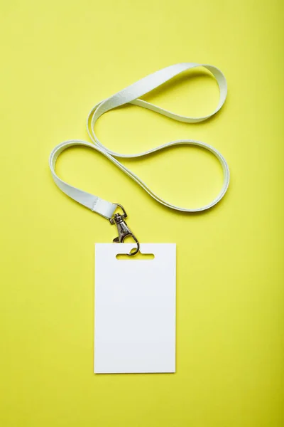 Bílé prázdné Id karty tag s mašlí na žlutém podkladu, maketa — Stock fotografie