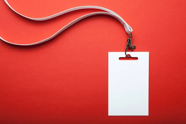 Blank name tag, with white lanyard on red. Name tag is blank for