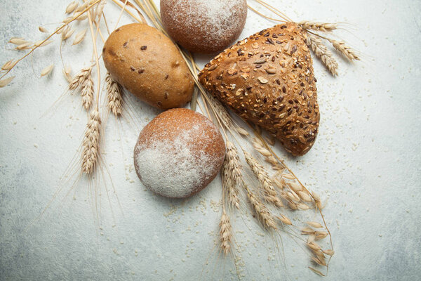 Rustic black bread and rye with wheat on an old antique white ta