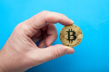 Kripto Döviz Alım bitcoin mavi bir arka plan üzerinde elinde.