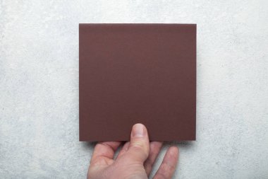 Kağıt, el ilanı, davet düzeni el üzerinde kahverengi kare levha