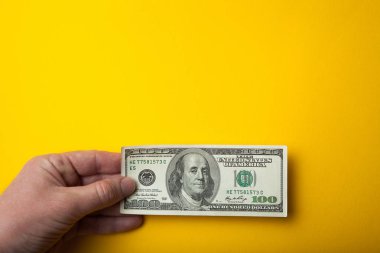 Eli boş alanı f, sarı bir arka plan 100 dolar tutar