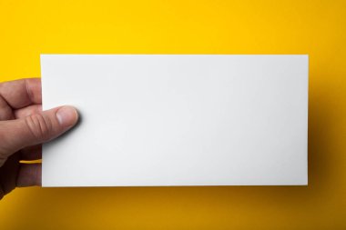 Bir adamın elini Dl el ilanı sarı bir arka plan üzerinde tutar..