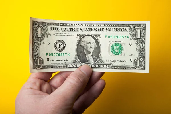 Dollar in man hand geïsoleerd op gele achtergrond. — Stockfoto