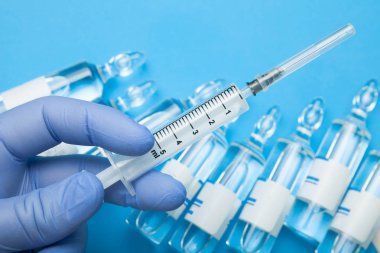 Yakın çekim, arka planı doktorun elinde bir şırınga 