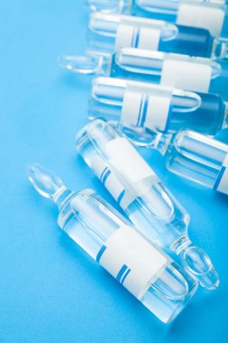 Mavi bir arka plan üzerinde kozmetik cerrahi tıbbi ampul.