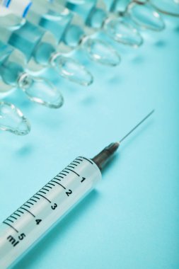 Mavi arka plan, kavram aşı üzerinde tıbbi şırınga.