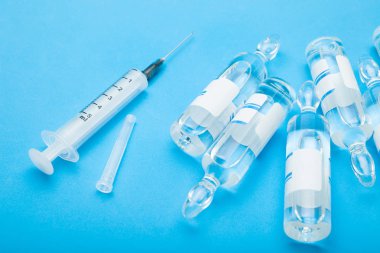 Ampul ve mavi arka plan, üstten görünüm üzerinde bir şırınga.