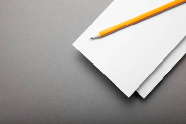 Kalem gri bir arka plan üzerinde beyaz kağıt el ilanı.