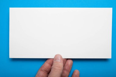 Kartpostal mavi bir arka plan üzerinde elinde boş beyaz düzeni.