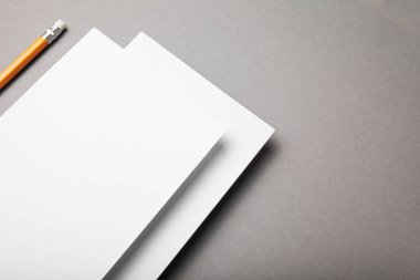 Beyaz kağıt ve kalem gri bir arka plan üzerinde.