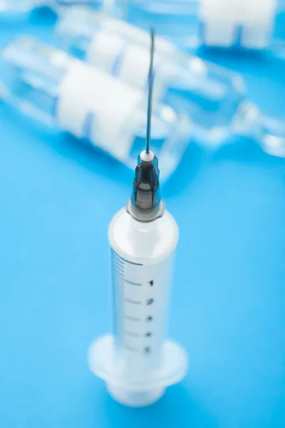 En medicinsk spruta på en blå bakgrund, begreppet immunizat — Stockfoto