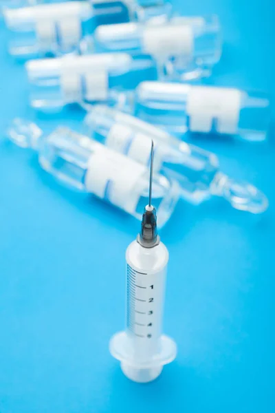 Medicinsk spruta med en nål på en bakgrund av ampuller på en b — Stockfoto