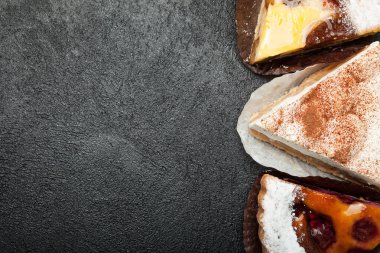 Kekler ve tatlılar bir siyah arka plan üzerine. Kopya alanı.