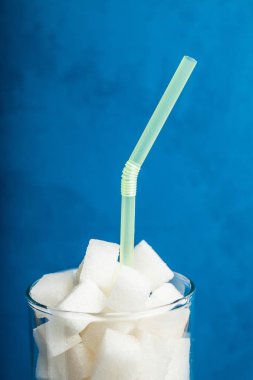 Cam ile mavi arka plan üzerinde dikey clos izole Lump & şeker