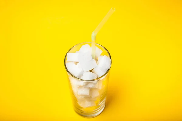 Glas mit Zuckerwürfeln und einem Rohr - die Zuckermenge im Glas — Stockfoto