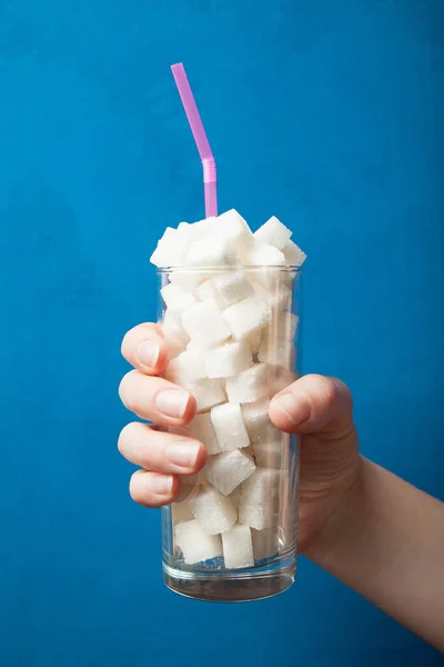 La strada per il diabete - la mano tiene un bicchiere con un sacco di refin — Foto Stock