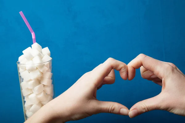 Zuckersucht, Herzzeichen und Zucker auf blauem Hintergrund. — Stockfoto