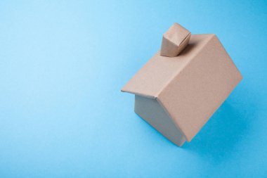 Karton mavi bir arka plan üzerinde yapılmış bir ev projesi.