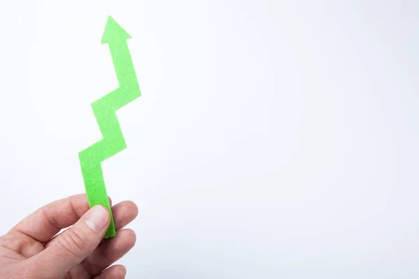 Green arrow to the top, as a sign of income. In a male hand on a — Stock Photo, Image