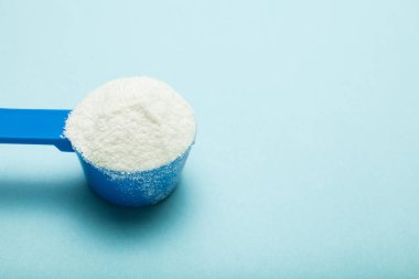 Mavi bir kaşığı süt tozu, metin için boş yer.