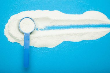 Mavi bir arka plan üzerinde bebek maması için süt tozu.