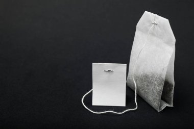 Beyaz çay poşeti siyah arka plan üzerine izole yakın çekim mockup.